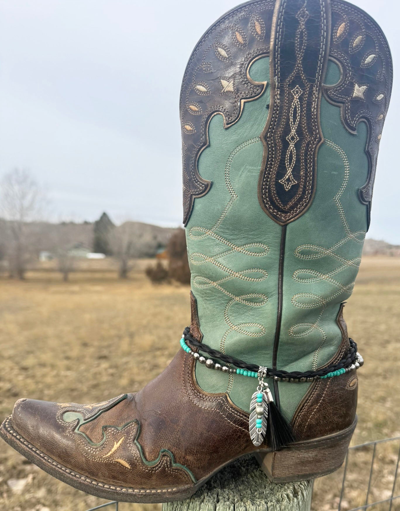 Clip-on horsehair charm with conchos and tassels hanging from a leather bag