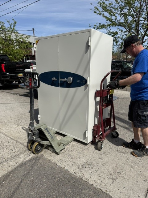 Double-door safe on a Wesco pallet jack at the curb.