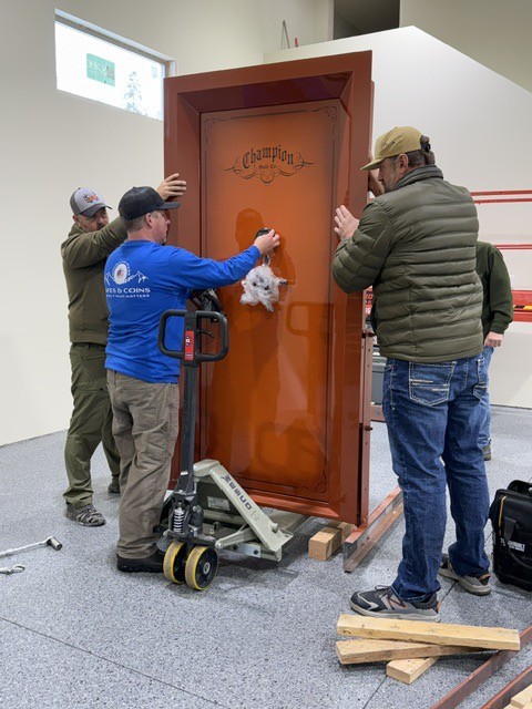 Crew setting a Champion safe door with a lifting jack.
