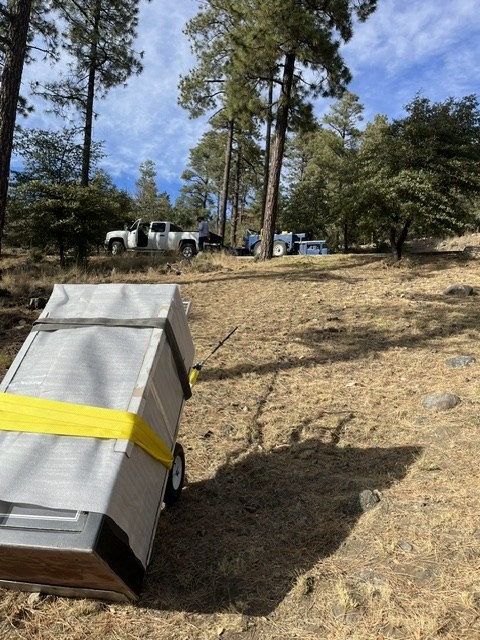 Blanketed safe on a hillside path with the crew truck in the pines.