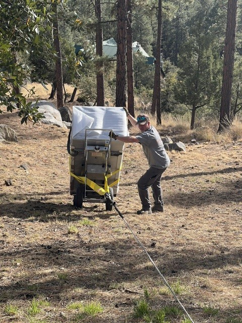 Wrapped safe on a powered dolly, winched down a pine hillside.