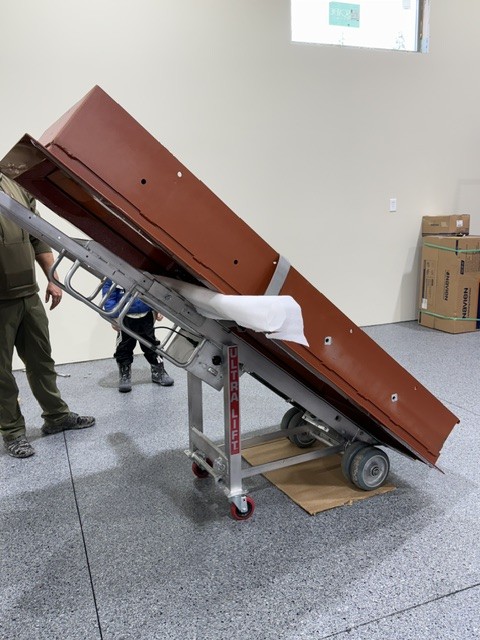 Ultra Lift stair climber carrying a large safe across a protected floor.