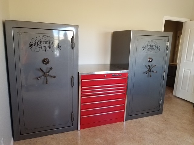 Two Superior safes placed in a garage beside a Snap-on tool chest.
