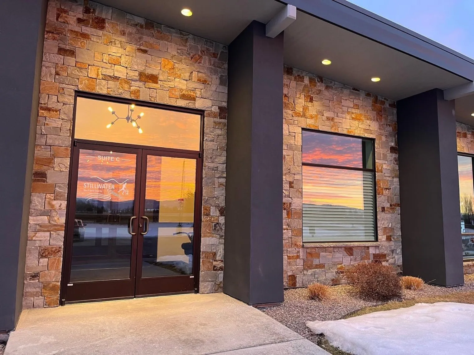 The Stillwater Spine and Sports Center entrance at Suite C, 3171 Hwy 93 N in Kalispell, Montana, at sunset